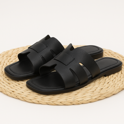 Schwarze Damenslipper aus Kunstleder – flache Sommerschuhe mit breiten Riemen und offenem Zehenbereich, minimalistisch und bequem für Alltag und Urlaub.
