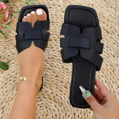 Schwarze Damenslipper aus Kunstleder – flache Sommerschuhe mit breiten Riemen und offenem Zehenbereich, minimalistisch und bequem für Alltag und Urlaub.